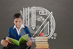 Student boy sitting on a table reading against grey blackboard with school and education graphic