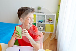 Student boy with smartphone distracting from study