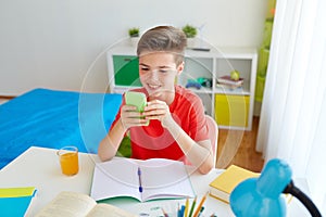 Student boy with smartphone distracting from study