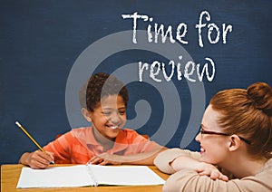 Student boy and teacher at table against blue blackboard with time for review text