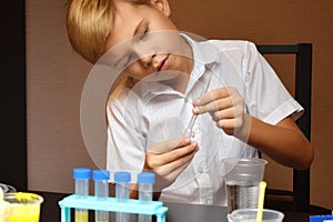 Student boy tinkering with test tubes. The child does experiments at home. Children`s home lab