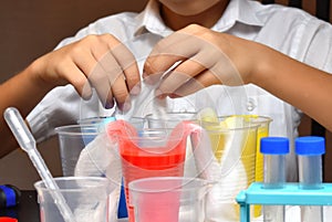 Student boy tinkering with test tubes. The child does experiments at home. Children`s home lab