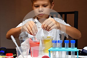 Student boy tinkering with test tubes. The child does experiments at home. Children`s home lab