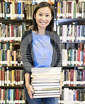 Student carrying books at the library