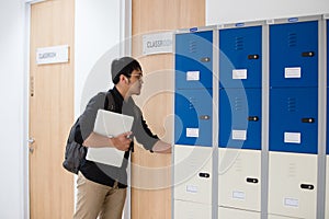 Student carrying laptop enter the classroom