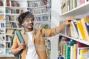 Student choosing book from library shelf for education and learning