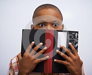 Student, classroom and hide face with book to read in front for classmates, shy and nervous. Elementary school, boy and