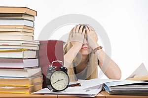 Student covering her eyes with her hands to take a break from their studies