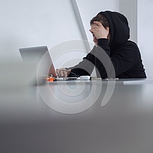 Student at desk. Working female. Woman qualified job. Searching for job. Girl in hoody sits at desk. Modern muslim woman