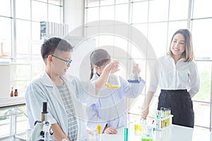 Student doing experiment with their teacher in chemistry classroom