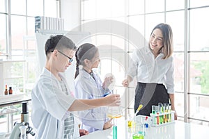 Student doing experiment with their teacher in chemistry classroom