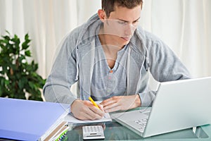 Student doing his homework with a laptop