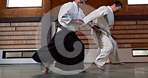 Student in dojo with sensei for aikido fight training, fitness and development with action, exercise and coaching