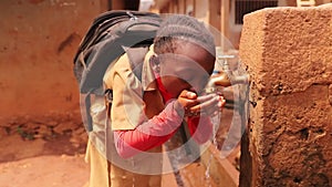 A student drinks water from a public fountain in africa, a concept of drought and water scarcity in africa