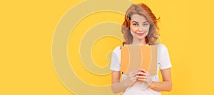 Student or female teacher with book. smiling girl hold planner on yellow background, reader. Woman  face