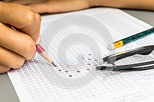 Student filling answers , drawing selected choice on answer sheets