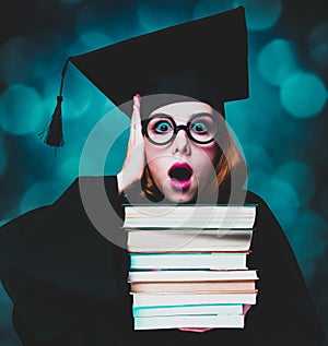 Student girl in an academic gown with books