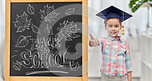 student girl in bachelor hat showing thumbs up