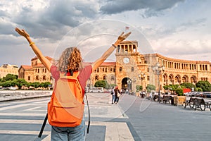 Student girl with a backpack raised her hands and rejoices wonderful view of the main tourist attraction of Yerevan -