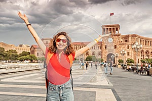 Student girl with a backpack raised her hands and rejoices wonderful view of the main tourist attraction of Yerevan -