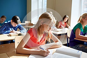 Student girl with book writing school test