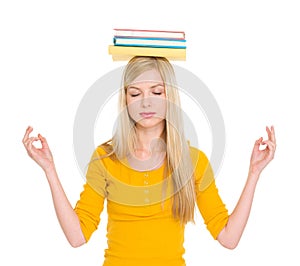 Student girl with books on head meditating