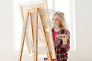 Student girl with easel painting at art school