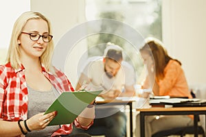 Student girl in front of her mates in classroom