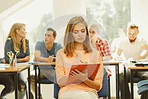 Student girl in front of her mates in classroom