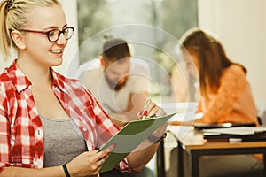 Student girl in front of her mates in classroom