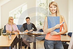 Student girl in front of her mates in classroom