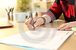 Student girl hands signing contract on a desk