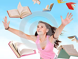 Student girl holding pile of books.