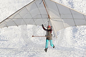 Student girl jumps with a beginner hang glider wing