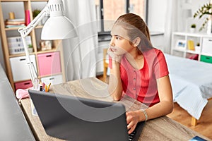 Student girl with laptop computer learning at home