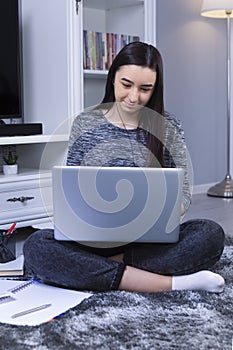 Student girl with laptop and headphones studying online