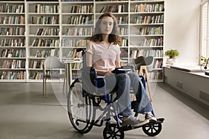 Student girl with mobility impairment posing for camera in library