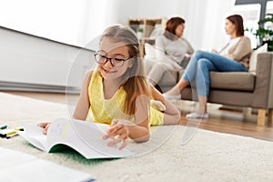 Student girl with notebook lying on floor at home