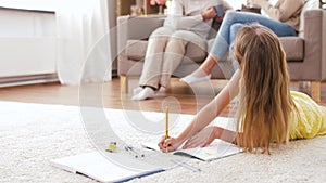 Student girl with notebook lying on floor at home