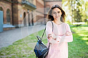 Student girl outside in summer park smiling happy. Caucasian college or university student. Young woman model wearing school bag o