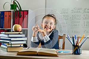 student girl politely listens to the teacher during the lesson in the classroom.