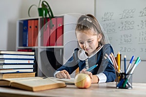 student girl politely listens to the teacher during the lesson in the classroom.