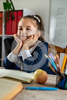 student girl politely listens to the teacher during the lesson in the classroom.