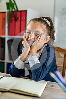 student girl politely listens to the teacher during the lesson in the classroom.