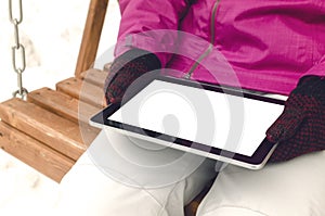 Student girl reading e-book on the bench in park. Digital tablet computer with blank isolated screen. Education background.