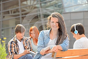 Student girl sitting outside campus with friends