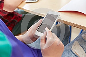 Student girl with smartphone texting at school