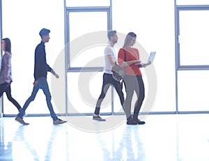 Student girl standing with laptop, people group passing by