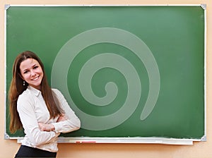 Student girl standing near blackboard in the classroom