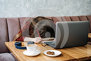 Student girl studying hard exam and sleeping on books in cafe. Tired Girl working